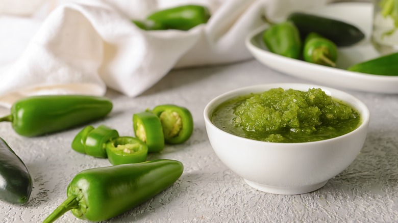 Salsa bowl surrounded by jalapenos 