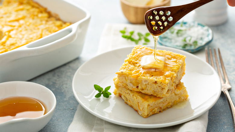 slices of cornbread on plate with butter and honey