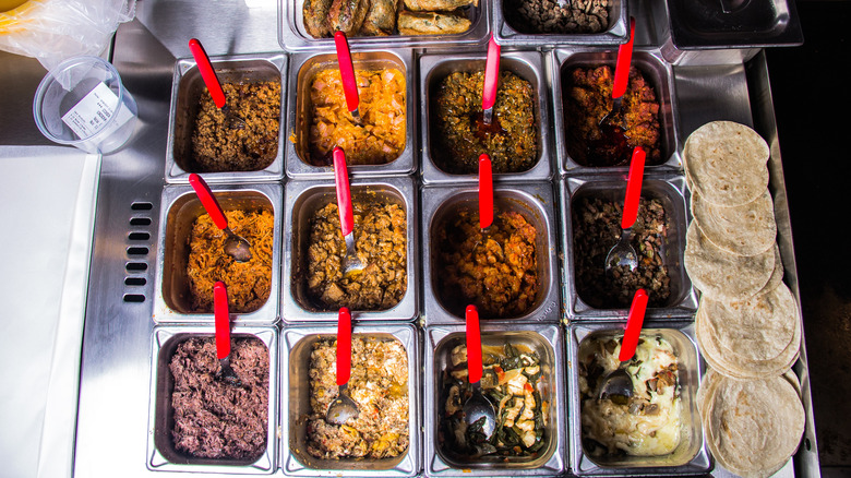 Taco ingredients in warmers at fast food counter