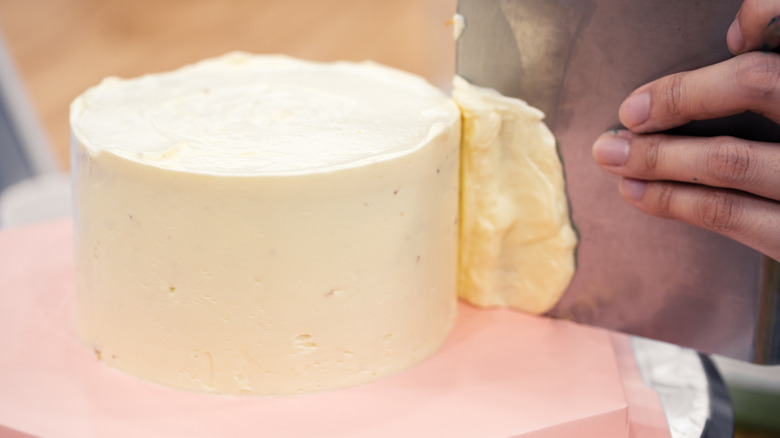 frosting a cake with scraper