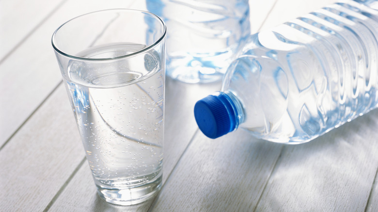 Two bottles water and a glass