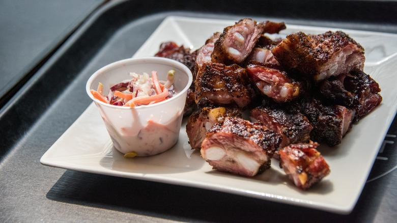A plate of smoked rib tips with a side of coleslaw
