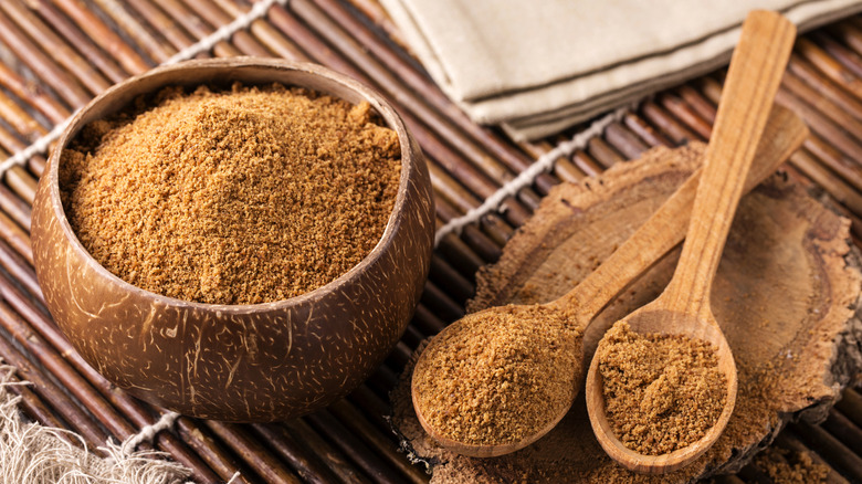 A coconut bowl and spoons of coconut sugar