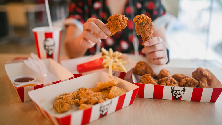 Woman holding KFC drumsticks