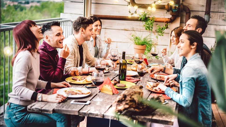Friends eating pizza with wine
