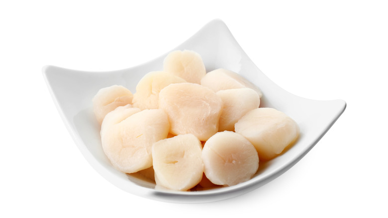 A bowl of fresh raw shelled scallops.