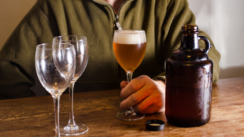 Growler with stemmed glasses of beer