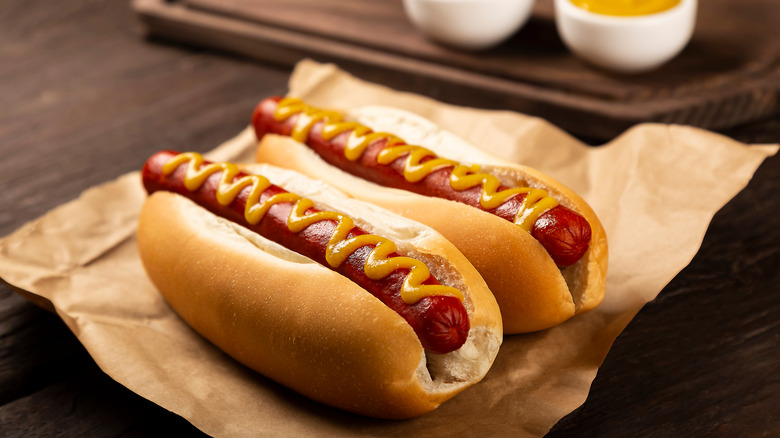 two hot dogs on parchment paper 