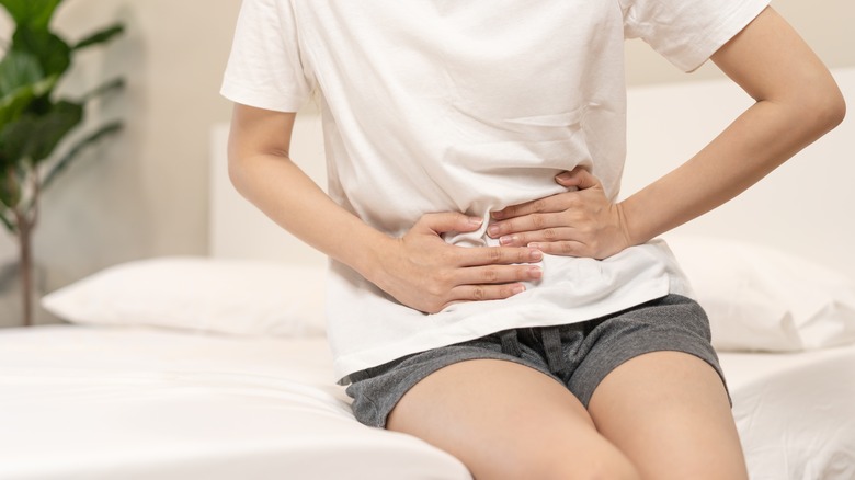 woman clutching stomach in pain