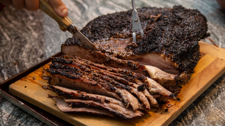 slicing beef brisket on board