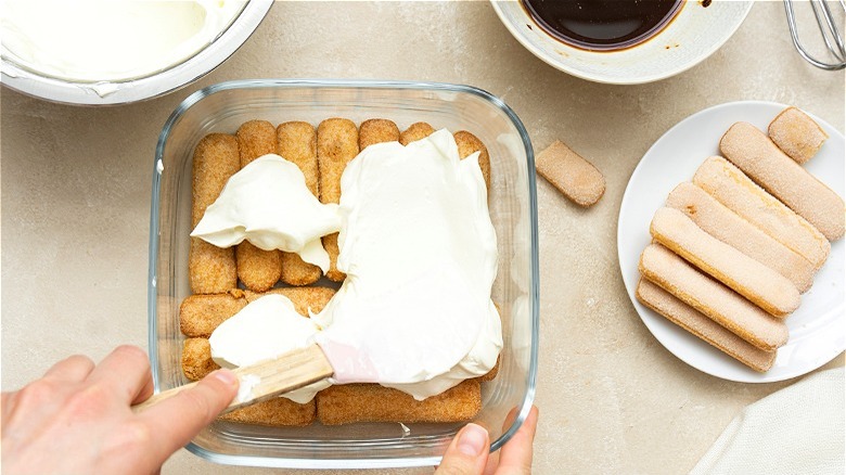 Hands assembling tiramisu 