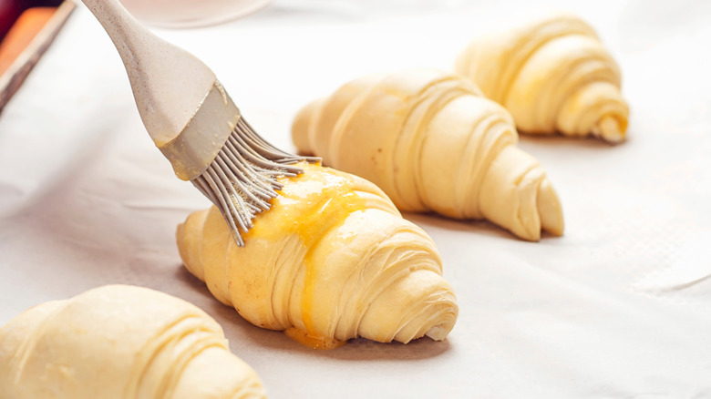Brushing egg wash on croissant