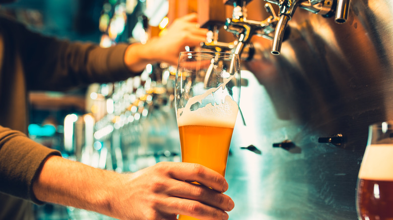 Person pouring beer from tap