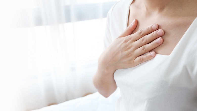 Woman witch acid reflux holding hand to chest 