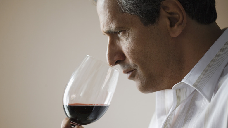 man smelling red wine