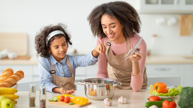 Mother daughter making dinner together 