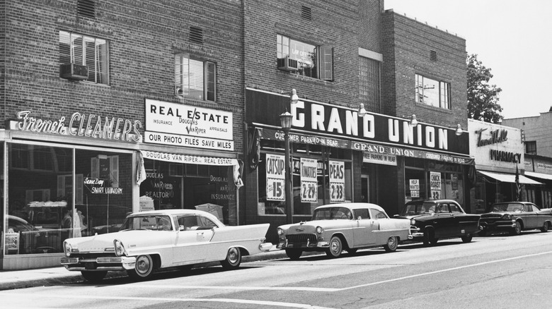 1930s cars parked in front of stores