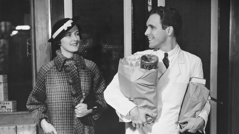 1940s woman and man carrying groceries