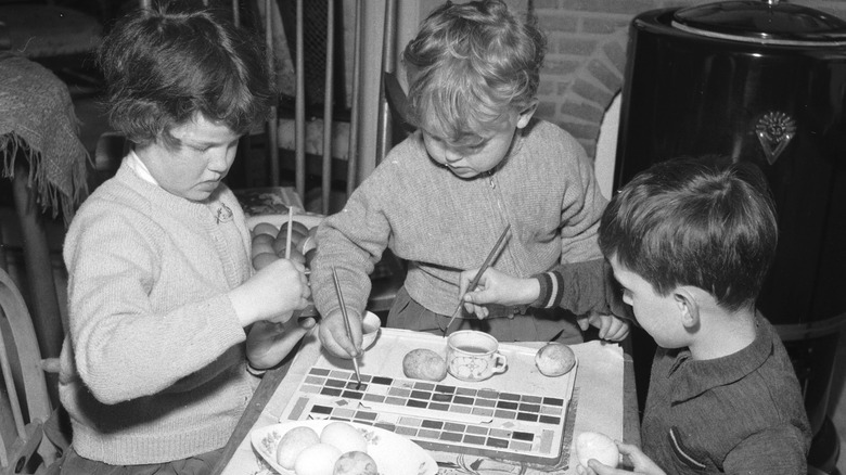 young kids painting eggs