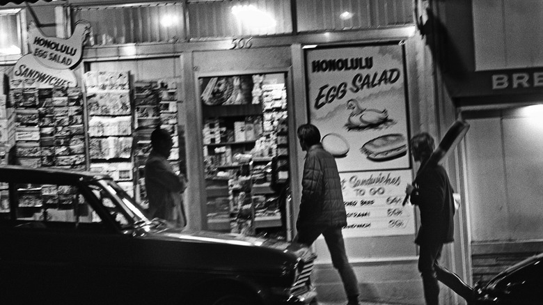 people walking past egg salad sign