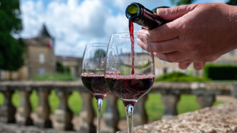 Red wine being poured into wine glasses