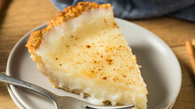 Close-up of a slice of egg custard pie on a white plate
