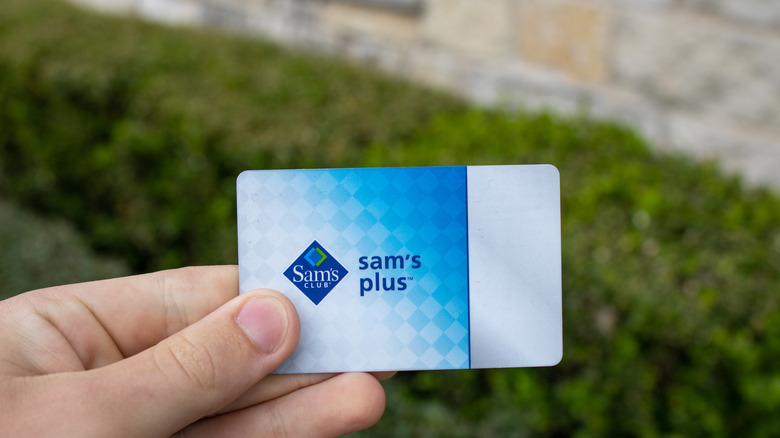 Person holding Sam's Club membership card