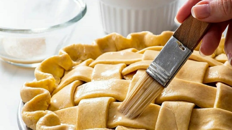 Brushing pie lattice with wooden brush