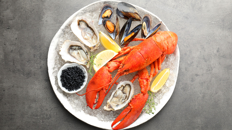 Plate of lobster, mussels, and oysters with lemon wedges and caviar