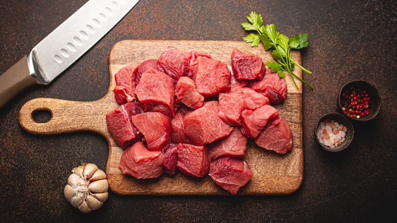 Raw beef cubes on cutting board