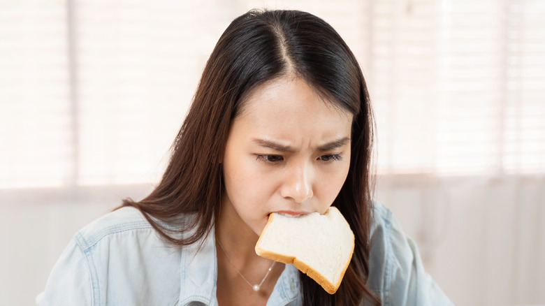 Woman with slice of bread in her mouth