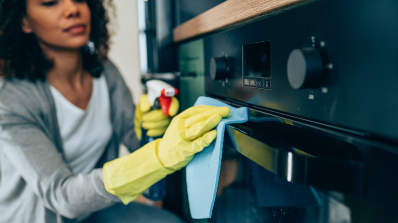 Person cleaning oven door