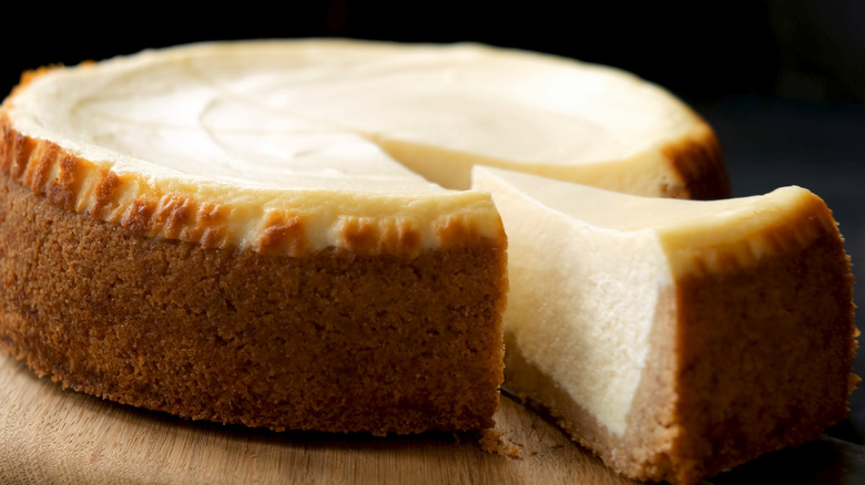 a slice cut from the entire cheesecake