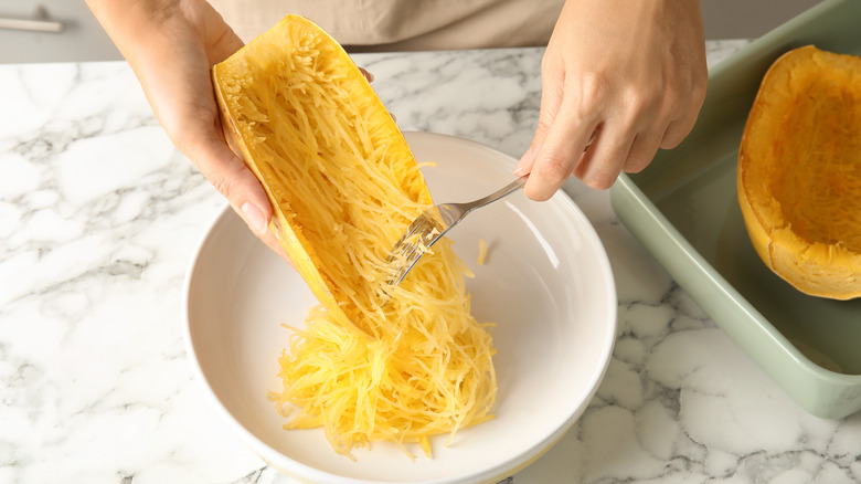 Person separating spaghetti squash strands