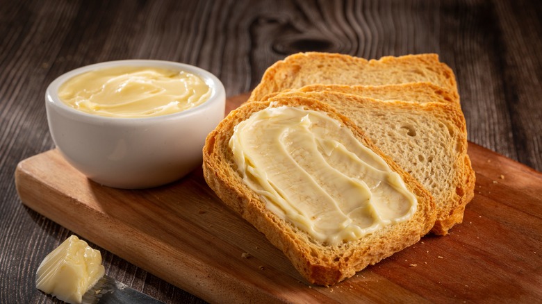 Slices of toast with butter on cutting board