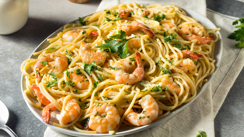 Shrimp scampi served in a baking dish, garnished with herbs.