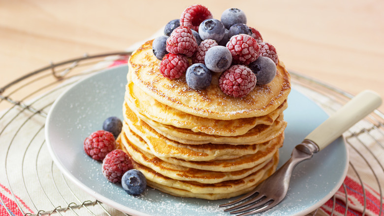 stack of pancakes topped with frozen berries