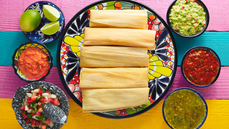 Tamales on plate surrounded by sides