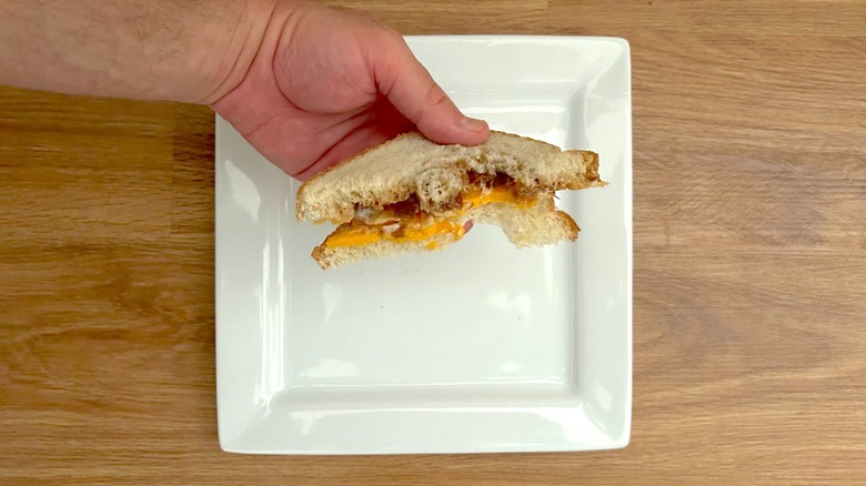 Partially eaten Branston pickle and cheese sandwich