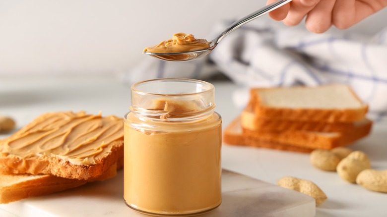 Peanut butter in a jar and on a spoon