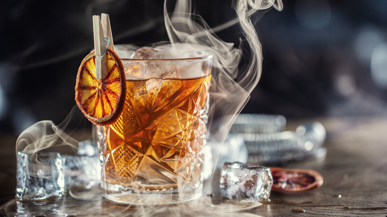 Old Fashioned cocktail surrounded by smoke