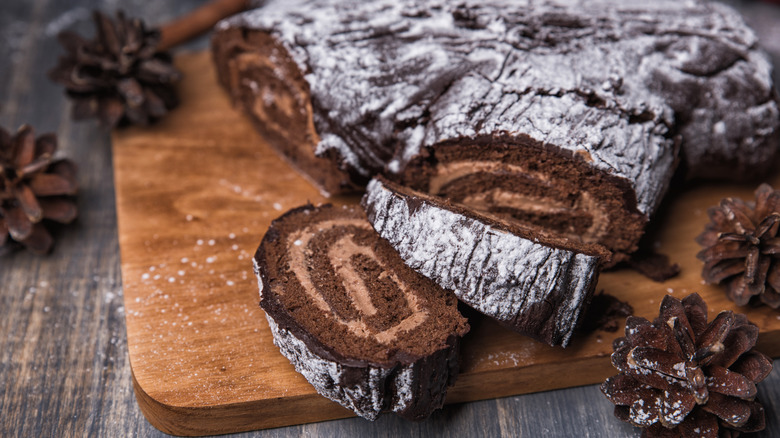 Chocolate yule log with pine cone background