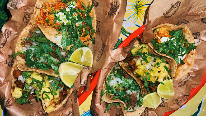 Mexican tacos with fresh cilantro and lime wedges