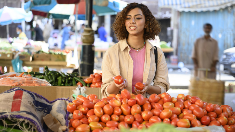 Choosing roma tomatoes at the store