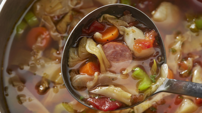 ladle filled with soup from pot