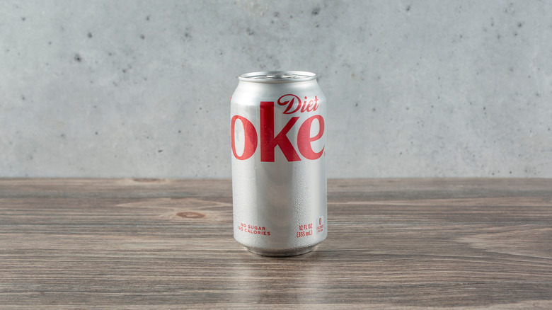 A single can of Diet Coke on a wooden table
