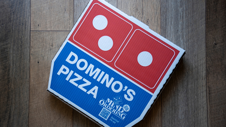Domino's pizza box on wooden floor