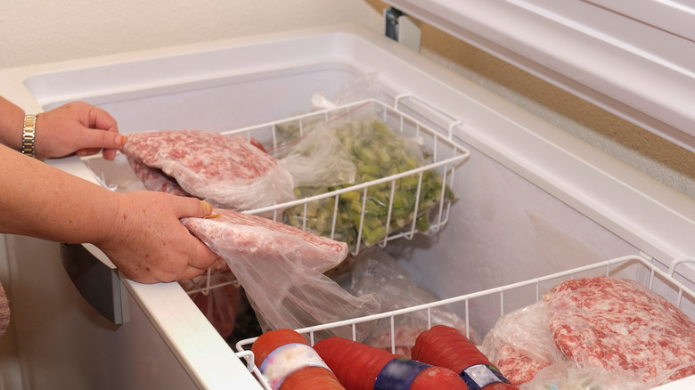 Person holding meat in freezer