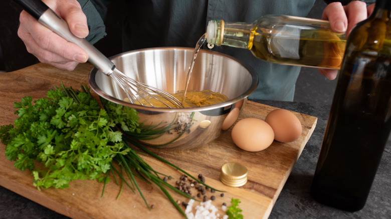 Man adding mustard oil to a bowl