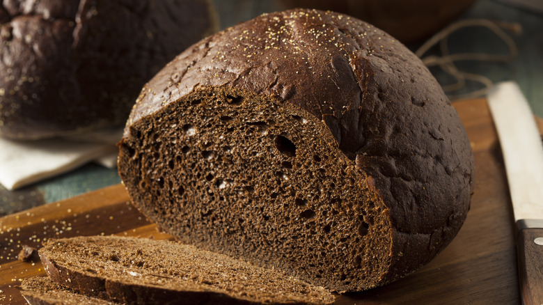 brown loaf of bread sliced on cutting board